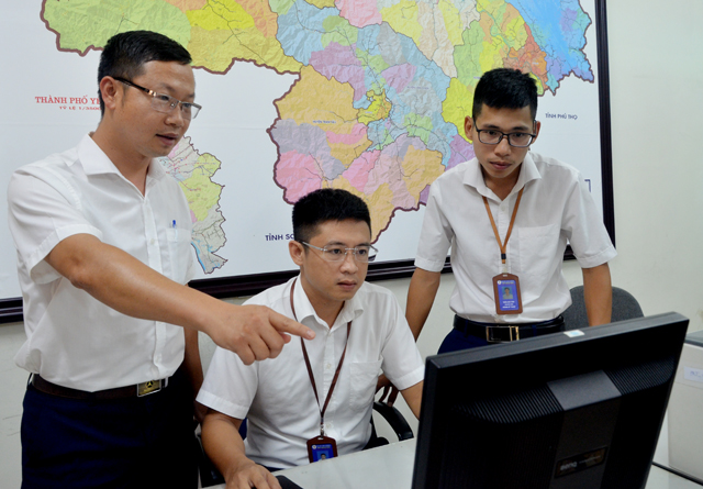 Kỹ sư Mai Vũ Sơn (bên trái) trao đổi nghiệp vụ với kỹ thuật viên Phòng Kỹ thuật Công ty Điện lực Yên Bái.